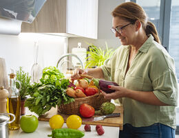 A woman looks over an assortment of vegetables.