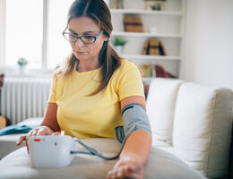  A woman measures her blood pressure at home