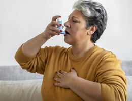 A woman using an inhaler.