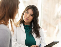 A doctor listens to a patient.