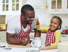 A father and daughter having fun in the kitchen.