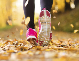 Feet running through fallen leaves.