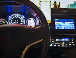 A car dashboard, steering wheel and infotainment system.