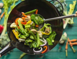 A variety of vegetables in a stir-fry pan.