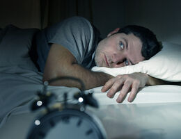 A man lies awake in bed.